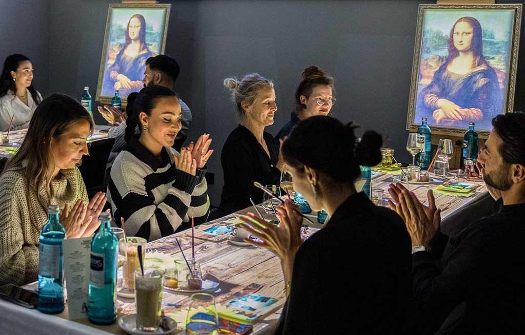 Guests applauding between two Mona Lisa paintings during the show